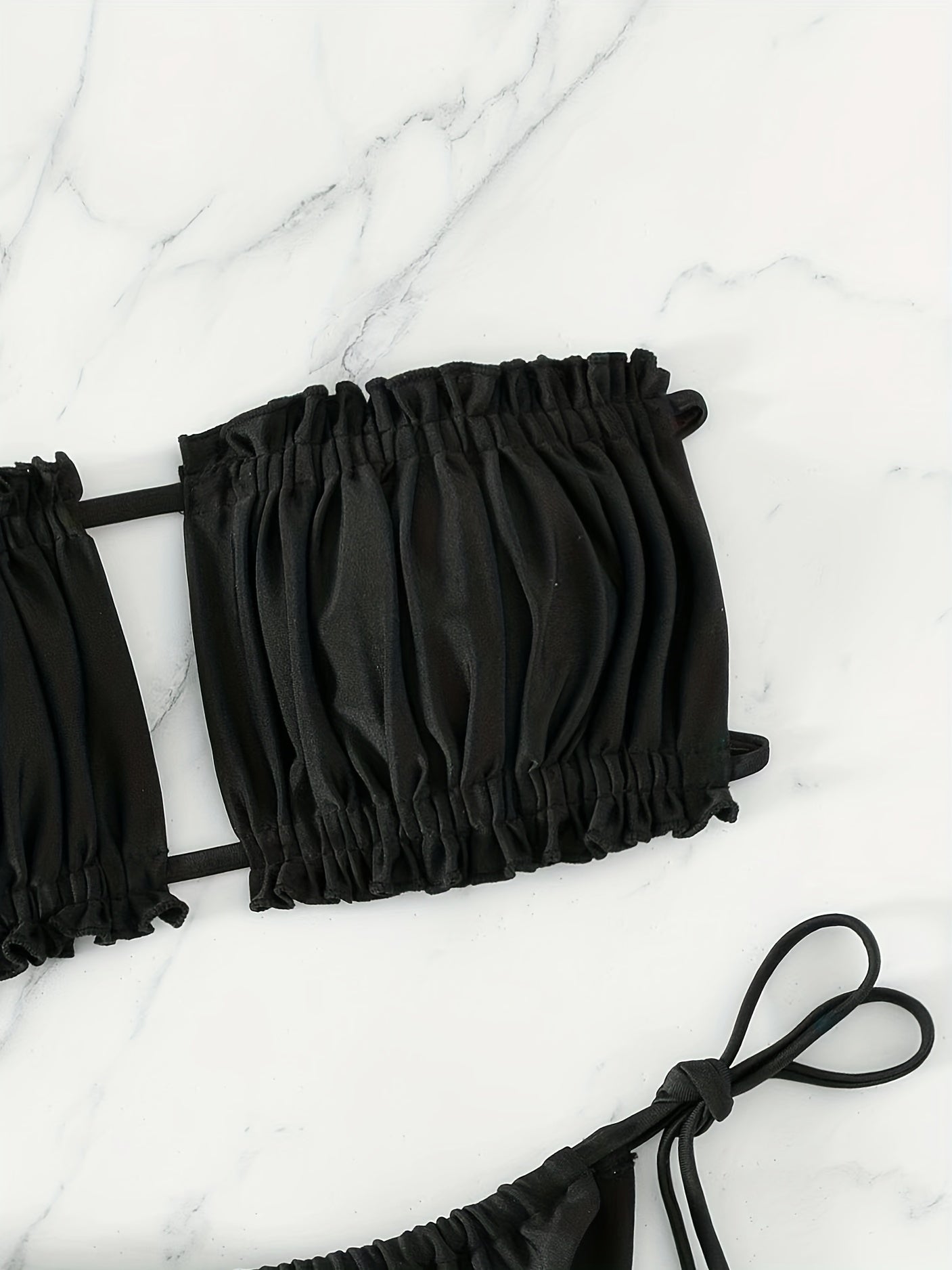 Maillot de bain deux pièces avec haut à cordons doubles et bas à nouer sur les côtés.